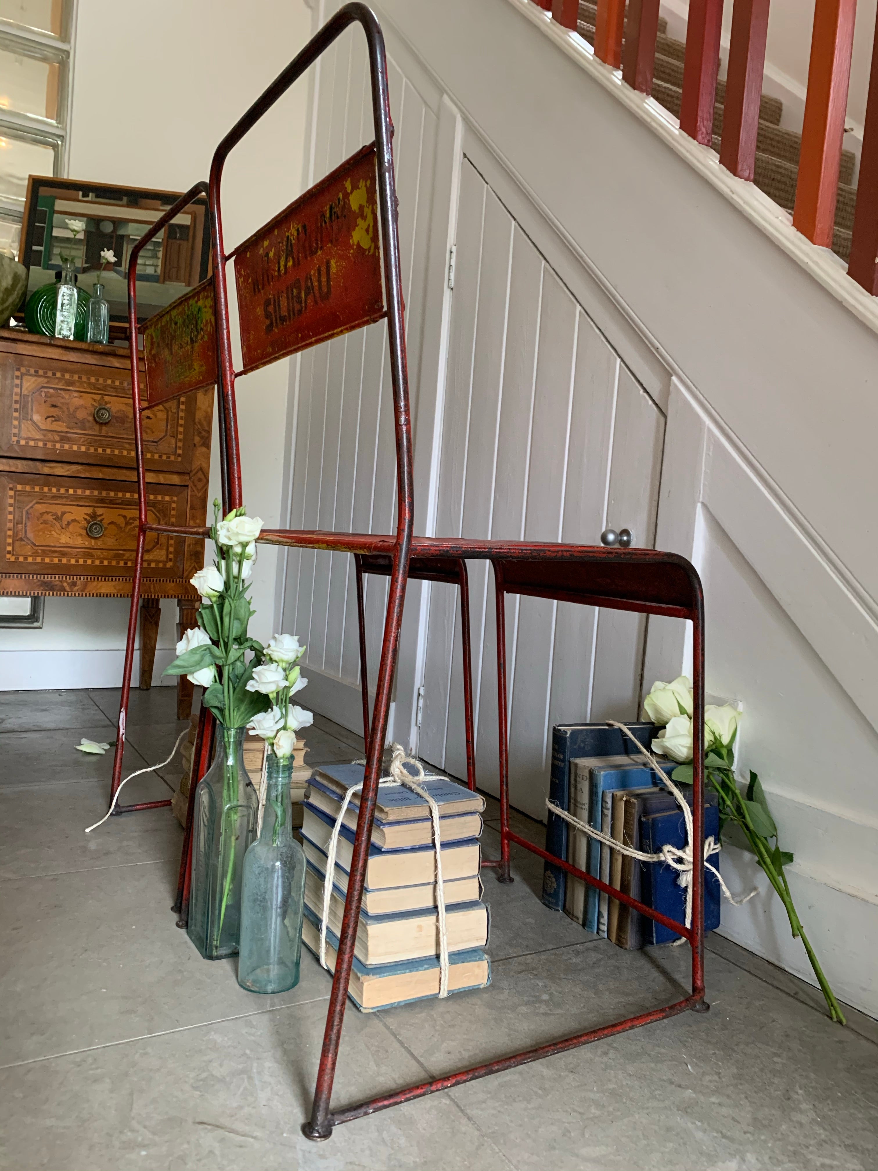 Pair of red/orange metal stacking chairs