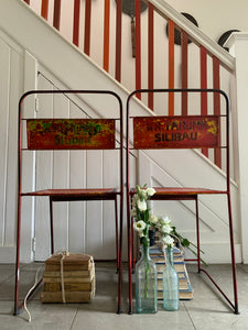 Pair of red/orange metal stacking chairs