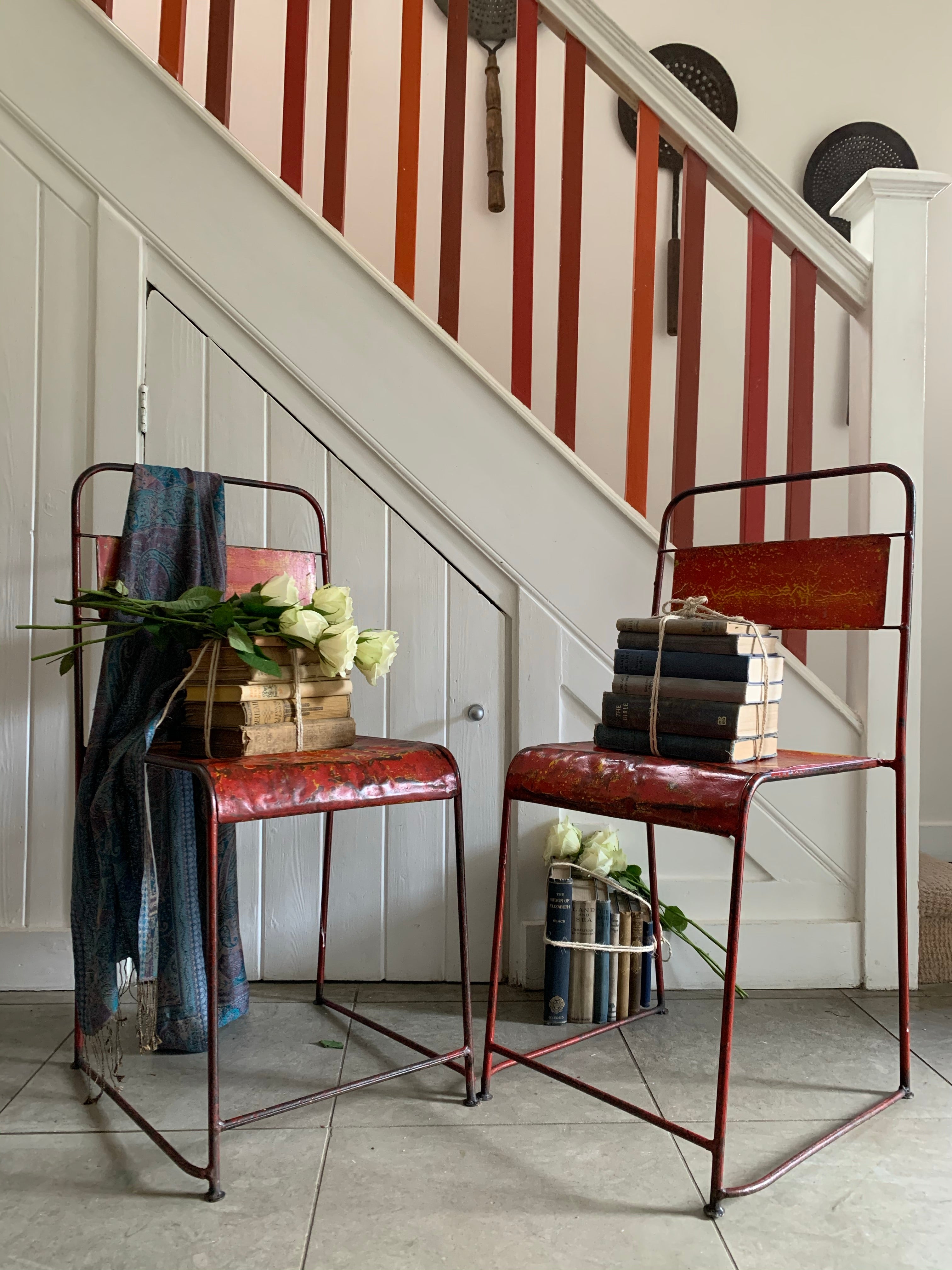 Pair of red/orange metal stacking chairs